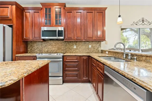 a kitchen with stainless steel appliances granite countertop a sink stove and microwave