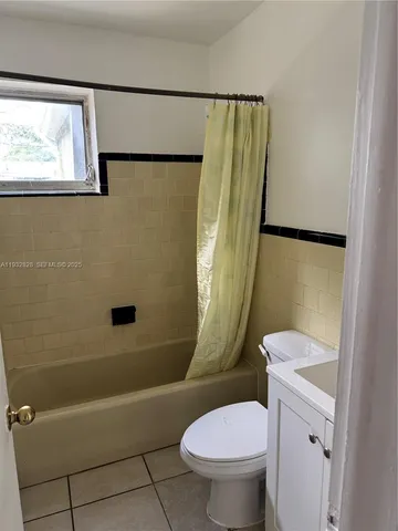 a white toilet sitting next to a bath tub and a shower