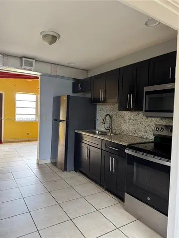 a kitchen with granite countertop a refrigerator and a sink