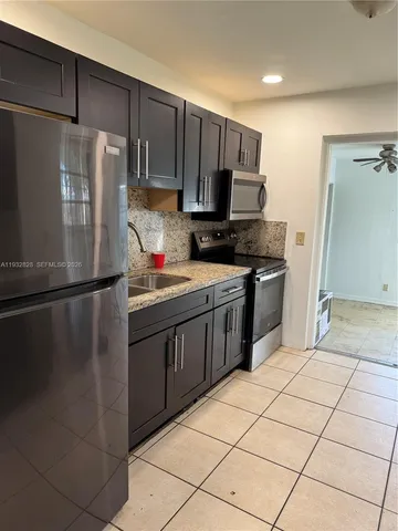 a kitchen with stainless steel appliances a refrigerator sink and microwave