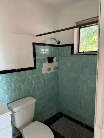 a bathroom with a toilet and a shower