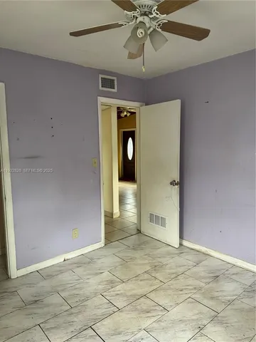 en empty room with an empty space and chandelier fan