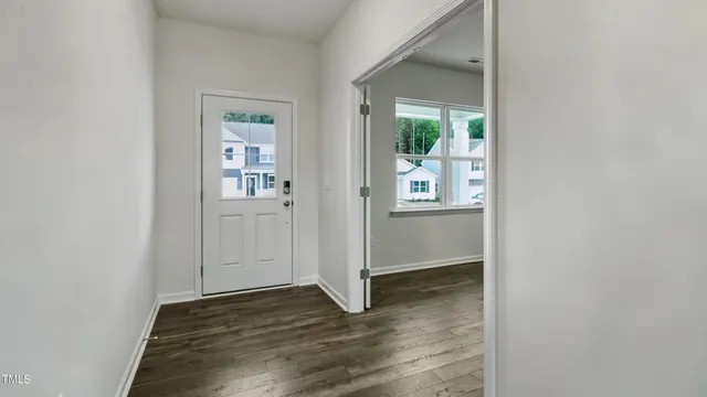an empty room with wooden floor and a way to dining room