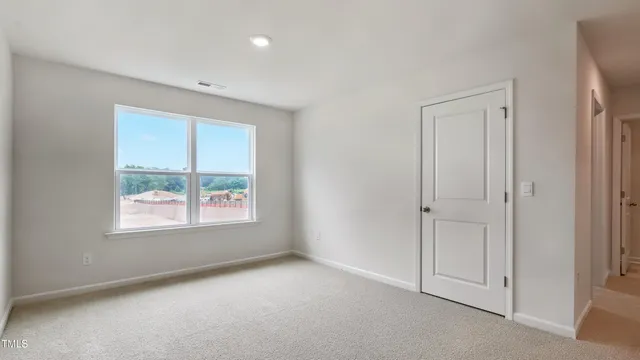 an empty room with windows and closet