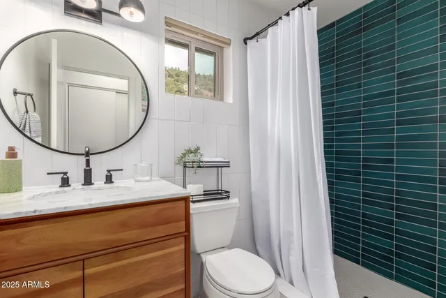a bathroom with a granite countertop toilet sink and mirror