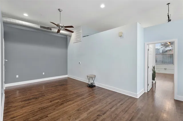 a view of a room with wooden floor and a ceiling fan