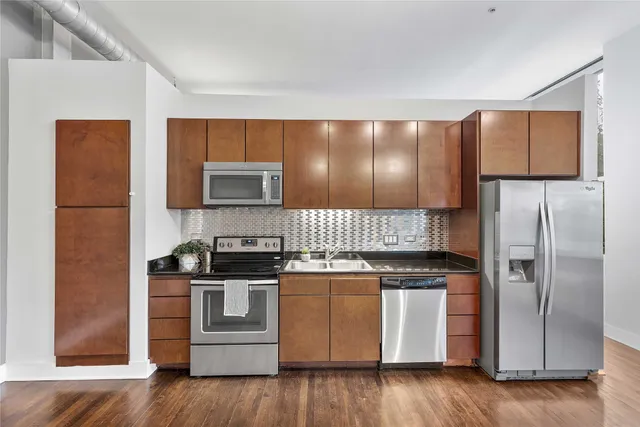a kitchen with stainless steel appliances granite countertop a stove a refrigerator and a microwave