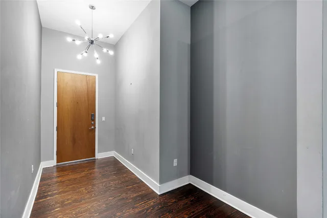 a view of an empty room with wooden floor