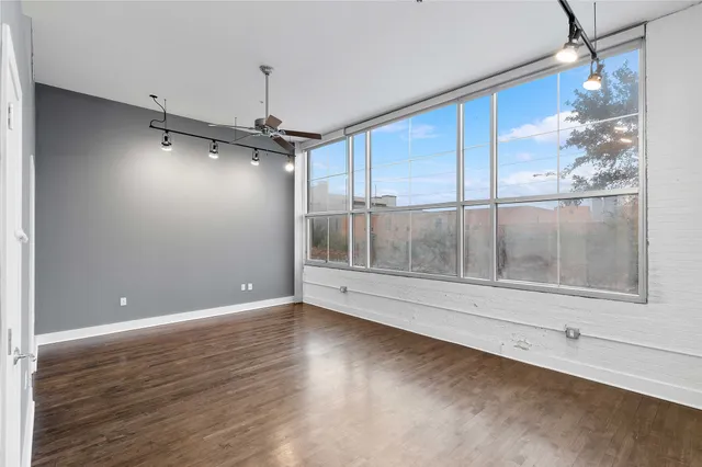 a view of a livingroom with wooden floor and a ceiling fan