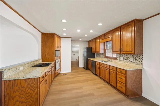 a large kitchen with stainless steel appliances granite countertop a large counter top and a stove