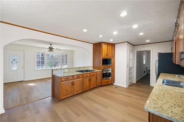 a kitchen with stainless steel appliances granite countertop a stove and a wooden floors