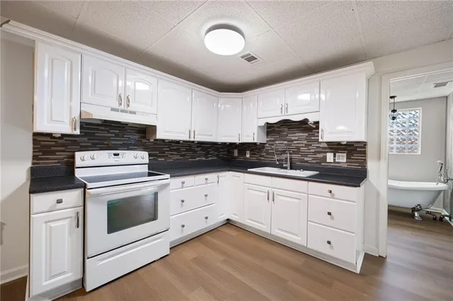 a kitchen with granite countertop white cabinets and white appliances