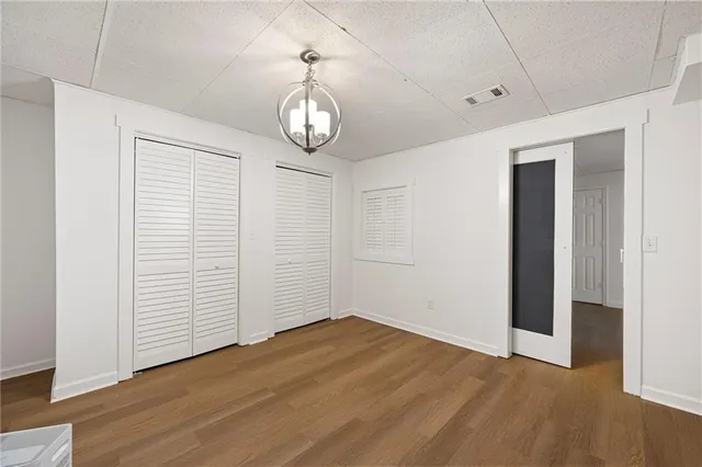 an empty room with wooden floor and ceiling fan