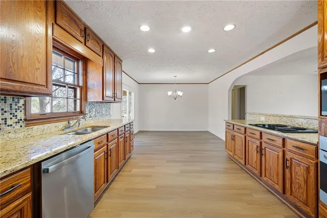 a large kitchen with stainless steel appliances granite countertop a large stove top oven a sink and dishwasher