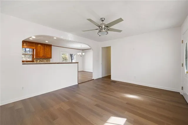 a view of a livingroom with wooden floor and a ceiling fan