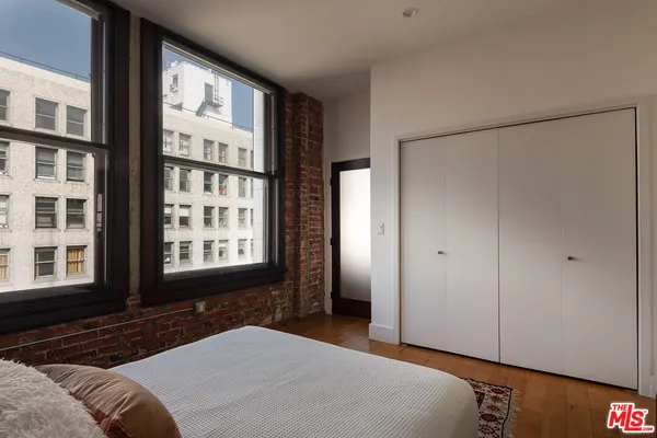 a bedroom with a bed next to a window