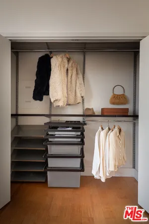 a view of walk in closet with clothes and shoes