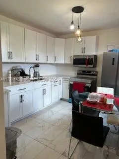 a kitchen with stainless steel appliances granite countertop a sink dishwasher stove top oven and cabinets