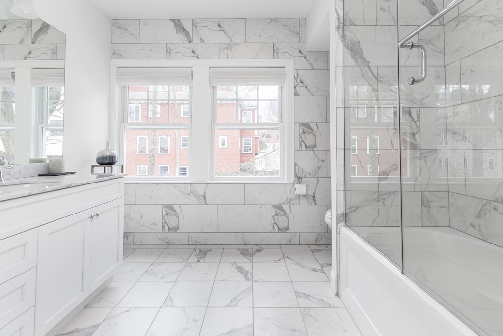 135 University Road, Unit 1 Brookline, MA 02445 - Photo 11 of 18 a bathroom with a bathtub sink and toilet