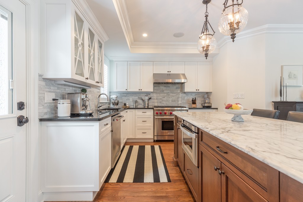 135 University Road, Unit 1 Brookline, MA 02445 - Photo 6 of 18 a kitchen with granite countertop a sink a counter space appliances and cabinets