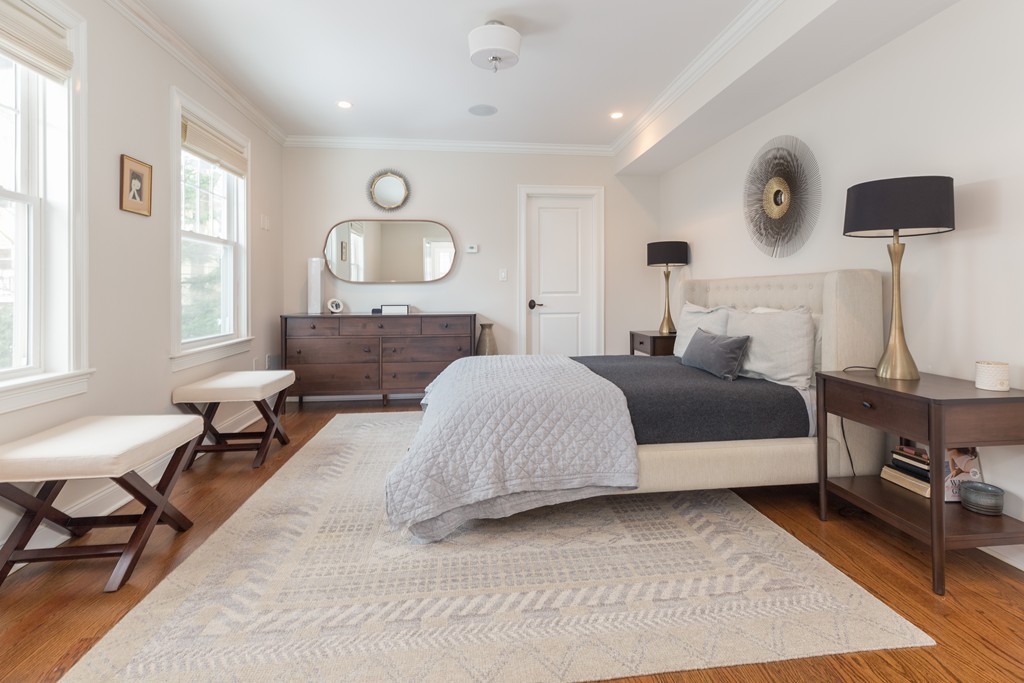 135 University Road, Unit 1 Brookline, MA 02445 - Photo 7 of 18 a bedroom with a bed a mirror and a window