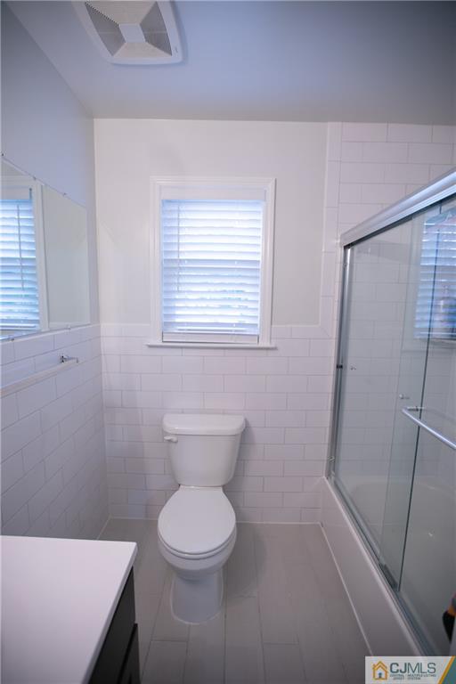 4308 Hana Road Edison, NJ 08817 - Photo 25 of 32 a bathroom with a toilet a sink a bath tub and a window