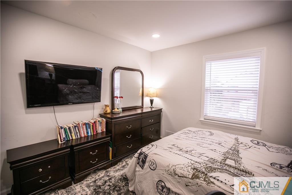 4308 Hana Road Edison, NJ 08817 - Photo 30 of 32 a bedroom with a bed and a flat screen tv