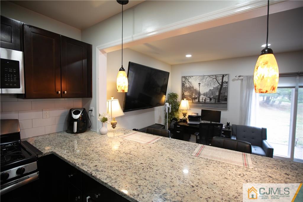 4308 Hana Road Edison, NJ 08817 - Photo 8 of 32 a kitchen with stainless steel appliances kitchen island granite countertop a sink a stove counter space and cabinets