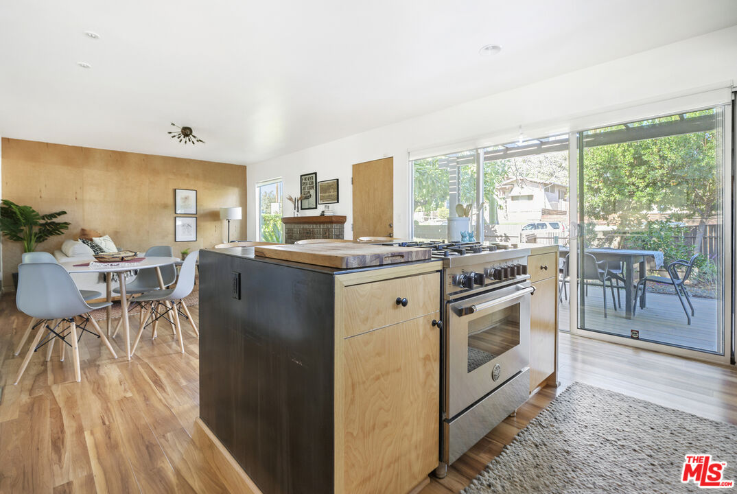5740 Meridian Street Los Angeles, CA 90042 - Photo 22 of 50 a kitchen with stainless steel appliances granite countertop a stove a sink a microwave dining table and chairs