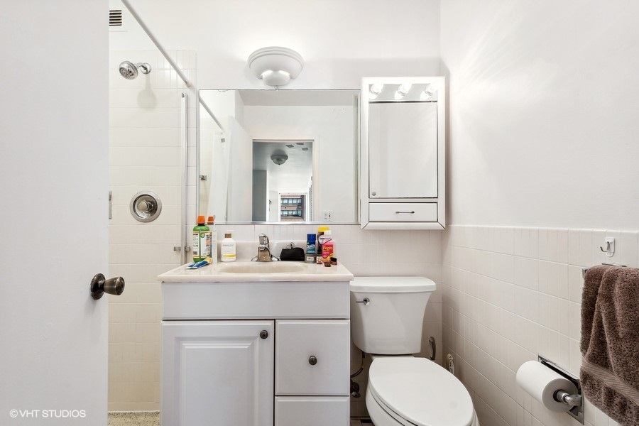 5701 North Sheridan Road, Unit 9L Chicago, IL 60660 - Photo 12 of 17 a bathroom with a sink vanity mirror and toilet