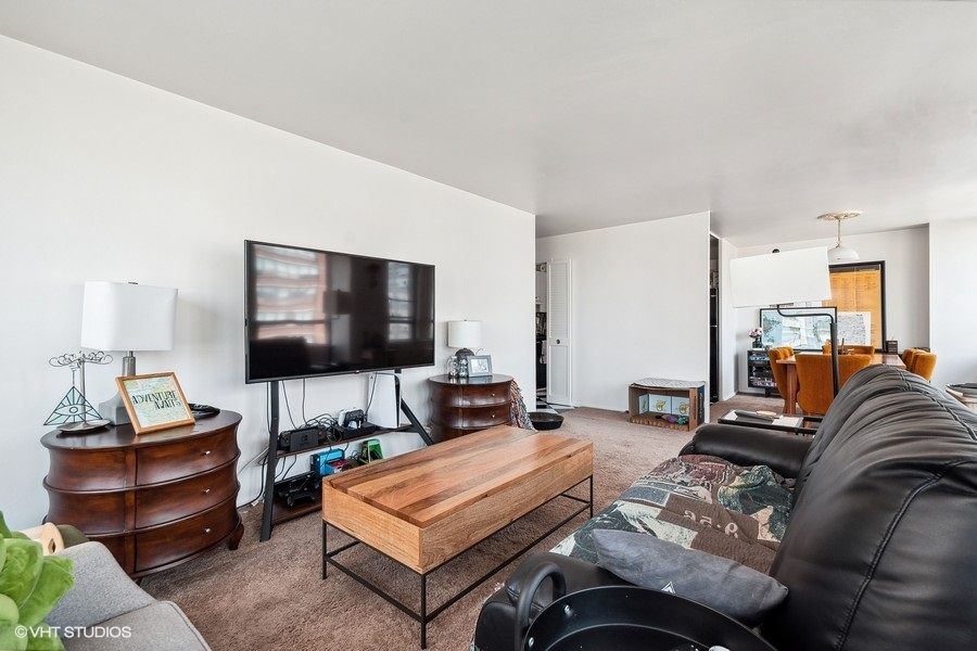 5701 North Sheridan Road, Unit 9L Chicago, IL 60660 - Photo 4 of 17 a living room with furniture and a flat screen tv