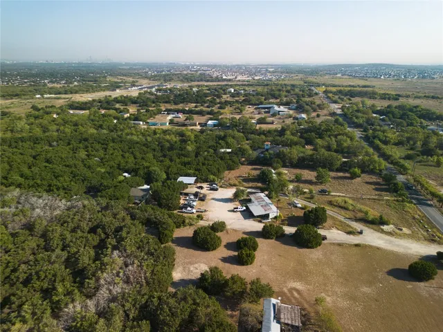 an aerial view of residential houses with outdoor space and trees