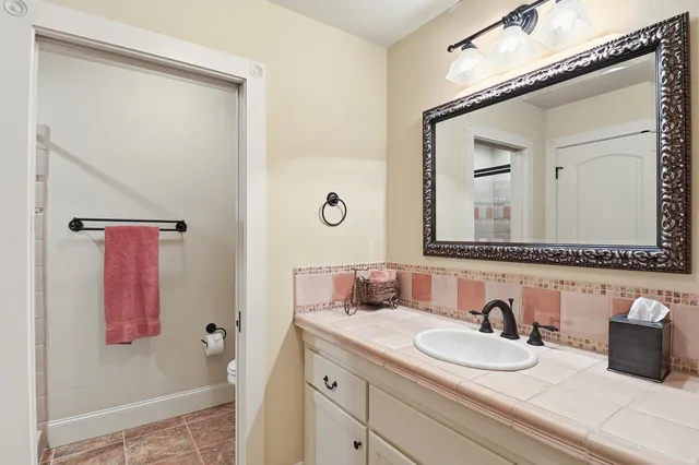 a bathroom with a granite countertop sink vanity and mirror