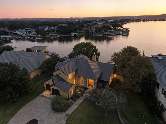an aerial view of a house with outdoor space and lake view