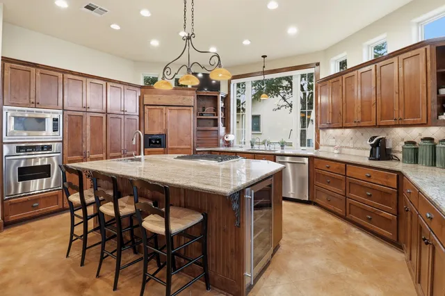 a kitchen with a table chairs refrigerator and microwave
