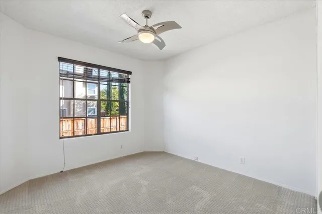 an empty room with a window and a fan