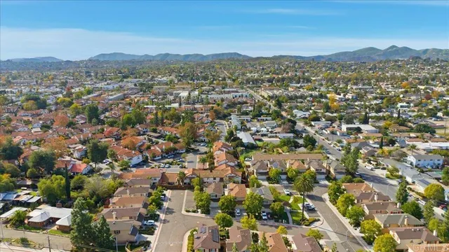 an aerial view of residential house with parking and city view