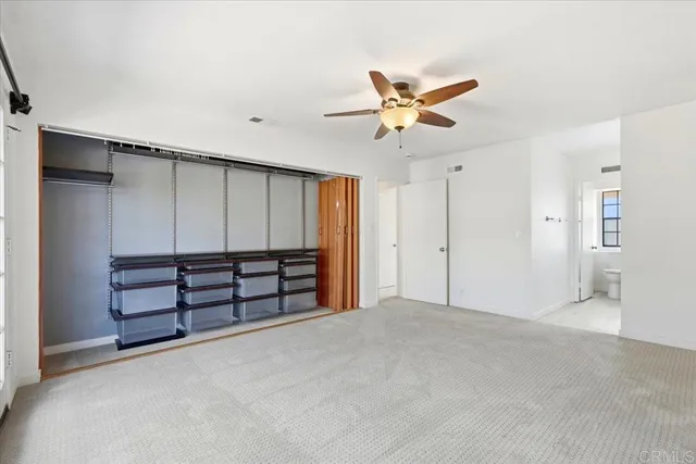 a view of an empty room with a ceiling fan