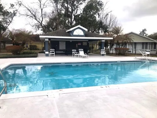 a view of a house with pool and sitting area