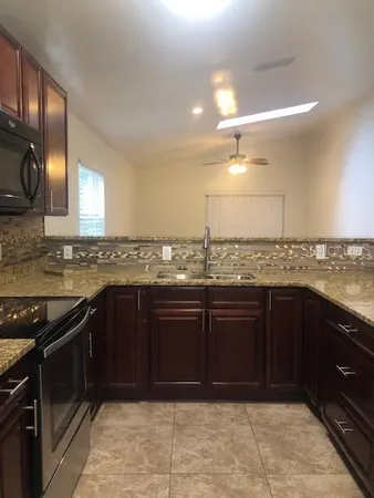 a kitchen with granite countertop stainless steel appliances and cabinets