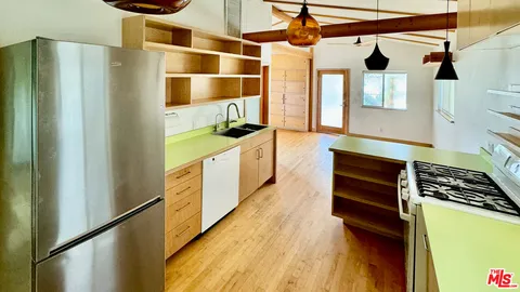 a kitchen with stainless steel appliances kitchen island granite countertop a sink and a counter top space