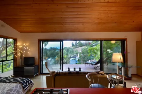 a living room with furniture a window and a flat screen tv