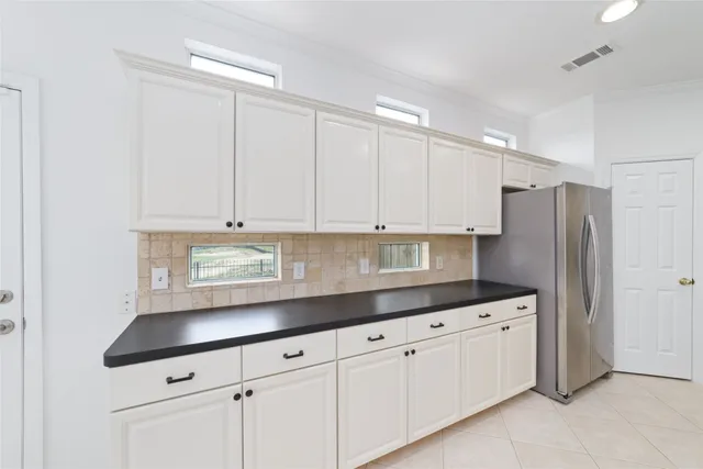 a kitchen with granite countertop white cabinets white stainless steel appliances and a sink