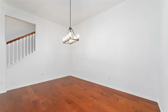 a view of a room with a hanging light and kitchen