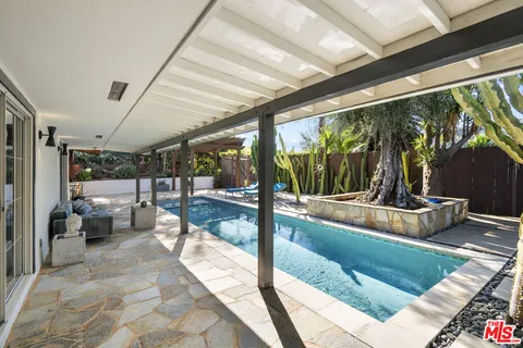 a view of swimming pool with a lounge chairs