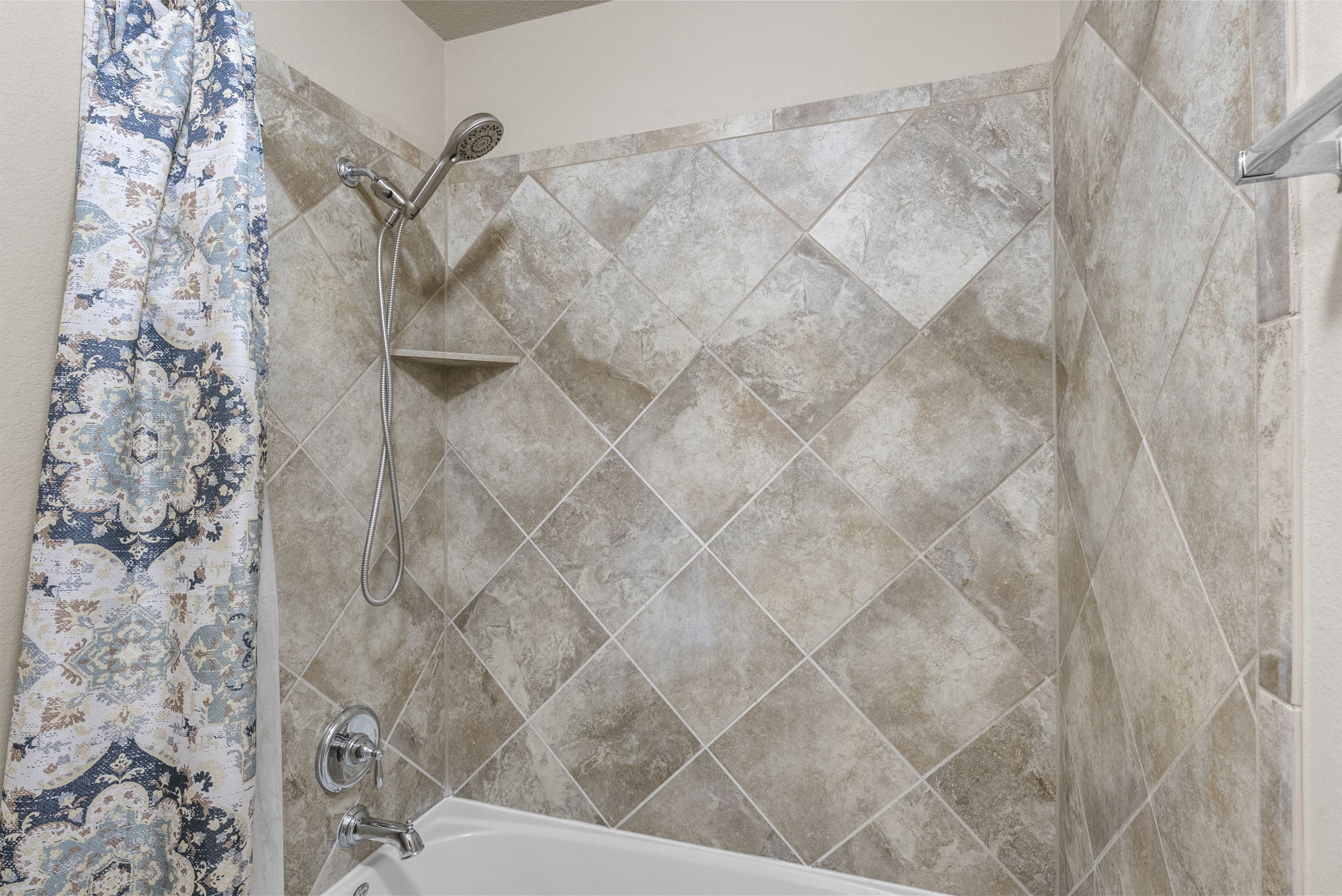 4401 Trinity Woods Street Leander, TX 78641 - Photo 23 of 37 A well-appointed bath features a tiled shower surround with a convenient integrated shelf.