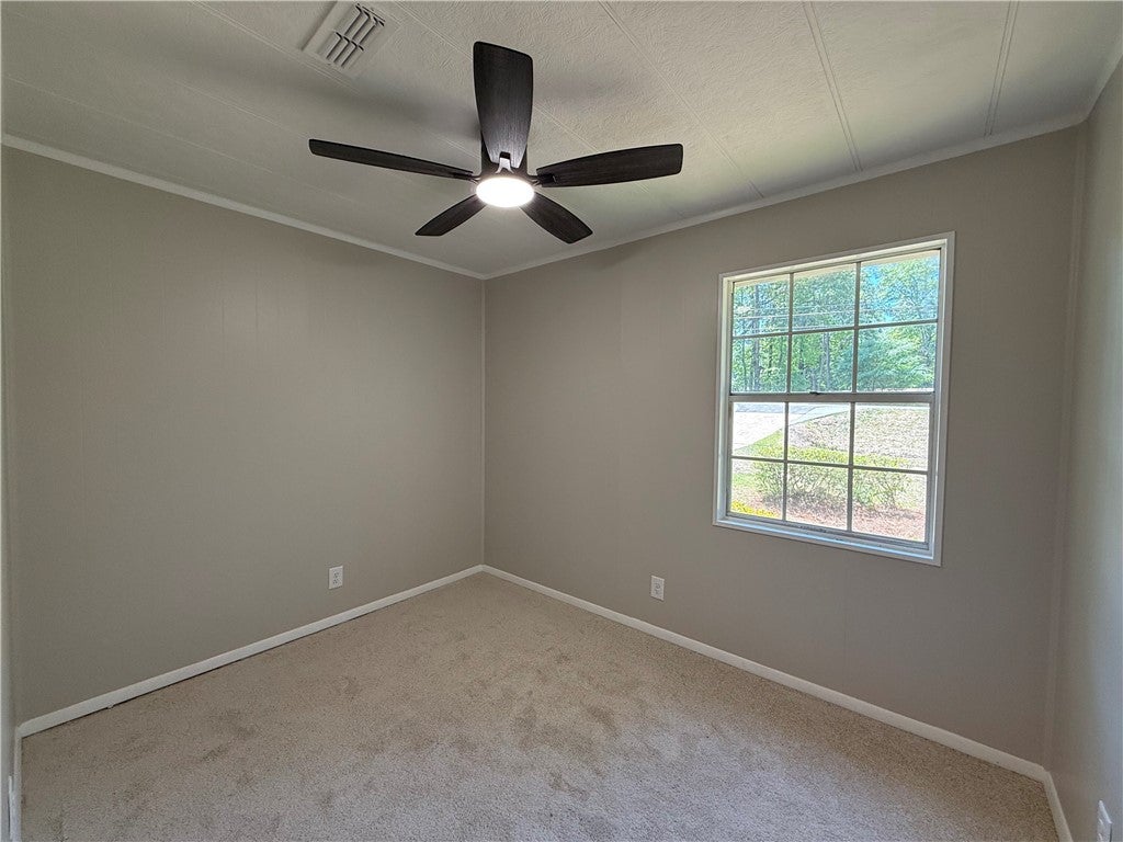 306 Crawford Road Opelika, AL 36804 - Photo 16 of 31 This cozy bedroom offers comfort and a tranquil view of nature through its large window.