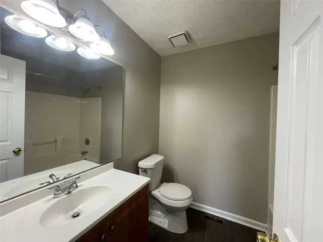 a bathroom with a sink vanity mirror and toilet