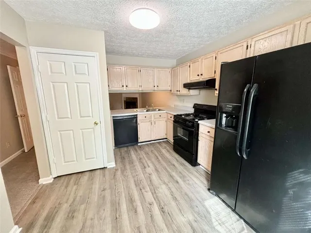 a kitchen with a refrigerator stove and white cabinets