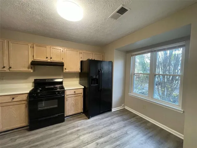 a kitchen with a stove a refrigerator and a stove top oven